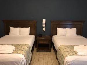 ein Hotelzimmer mit 2 Betten mit weißer Bettwäsche in der Unterkunft Hotel las Margaritas Merida in Mérida