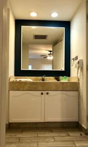 ein Badezimmer mit einem Waschbecken und einem großen Spiegel in der Unterkunft Hotel las Margaritas Merida in Mérida