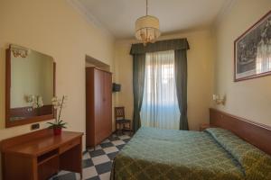 a bedroom with a bed and a desk and a mirror at Hotel Giorgina in Rome