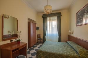 a bedroom with a bed and a desk and a mirror at Hotel Giorgina in Rome
