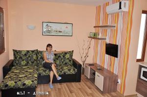 een vrouw op een bank in een woonkamer bij Лорета-Камен бряг in Kamen Bryag
