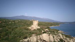 a monument on top of a hill next to the water at Chez Fred et Marie in Figari