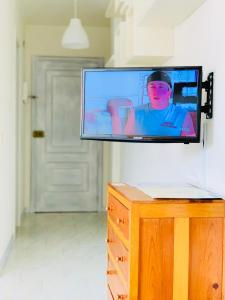 einen Flachbild-TV, der an einer Wand hängt in der Unterkunft Estudio 4 en el centro de Pontevedra in Pontevedra