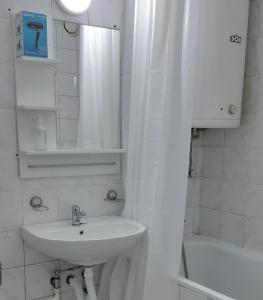 ein Badezimmer mit einem Waschbecken, einem Spiegel und einer Badewanne in der Unterkunft Sarajevska Studio & Apartment in Belgrad