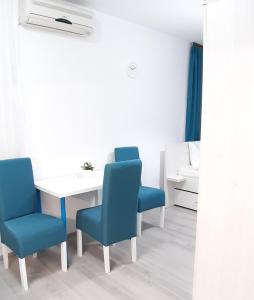 Zimmer mit einem Tisch und zwei blauen Stühlen in der Unterkunft Sarajevska Studio & Apartment in Belgrad