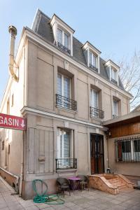 - un bâtiment avec des chaises devant dans l'établissement Cameleon Paris Guesthouse, à Pantin