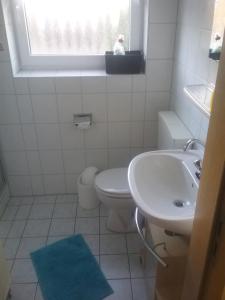 La salle de bains est pourvue de toilettes, d'un lavabo et d'une fenêtre. dans l'établissement Seemöwe, à Bedekaspel