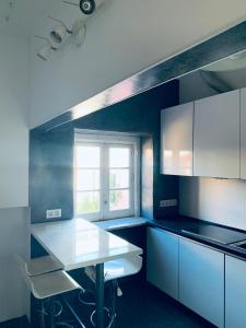 cocina con armarios blancos, mesa y ventana en Restelo House Shared Appartment en Lisboa