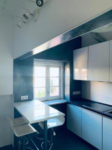 a kitchen with white cabinets and a table and a window at Restelo House Shared Appartment in Lisbon
