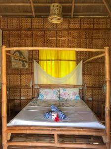 a bed in a bamboo room with a yellow curtain at Buenavista Paradise Resort in Looc