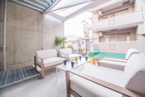 a balcony with chairs and tables on a building at URBAN LODGE Komagome in Tokyo