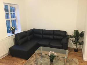 a living room with a black couch and a table at Quiet Residential Area Within Easy Reach Of Town in Manchester