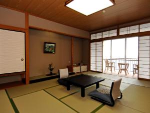 a room with a table and chairs and a balcony at Mikawa Bay Hills Hotel in Nishio