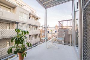 a balcony with a table and chairs and a plant at URBAN LODGE Komagome in Tokyo