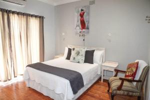 Un dormitorio con una cama blanca y una silla. en LORD WILLIS, en Williston