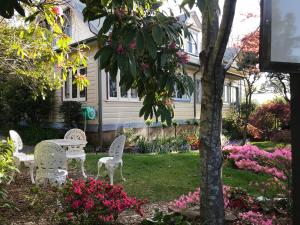 a table and chairs in a yard with flowers at Kurrara Historic Guest House in Katoomba