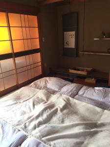 an unmade bed in a room with a mirror at Guest House Mitsuka in Shishikui