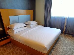 Postel nebo postele na pokoji v ubytování Kinabalu Daya Hotel