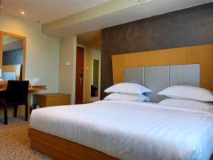 Postel nebo postele na pokoji v ubytování Kinabalu Daya Hotel