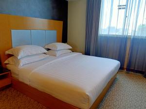 Postel nebo postele na pokoji v ubytování Kinabalu Daya Hotel