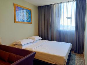 Postel nebo postele na pokoji v ubytování Kinabalu Daya Hotel