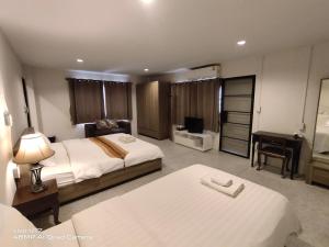 清迈清迈旅馆的一间酒店房间，里面有两张床和一张桌子。