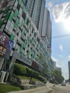 a large building with green windows on a city street at Delight Homestay Twin Galaxy in Johor Bahru