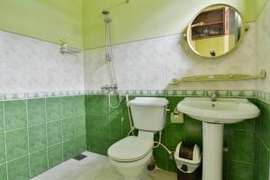 un bagno con un water, un lavandino e uno specchio di Expeditor Kandy a Kandy