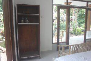 een kamer met een houten boekenplank naast een raam bij Umah De Arlika UBUD in Ubud