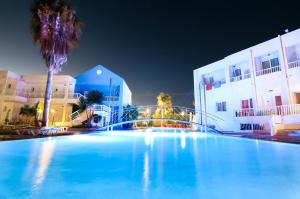 
a large swimming pool in front of a large building at Valsami Hotel Apartments in Kremasti
