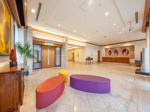 a lobby with colorful seating in a building at President Hotel Mito in Mito