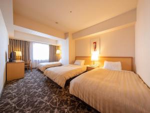 a hotel room with two beds and a window at President Hotel Mito in Mito +26 photos