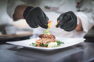 a person cutting a piece of food with a knife at Majestic Hotel & Spa Resort in Brunico