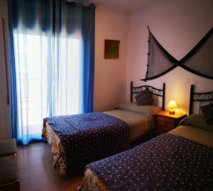 a bedroom with two beds and a window at Relajante casa Climatizada Parking privado y Cerca del Mar in Miami Platja +22 photos