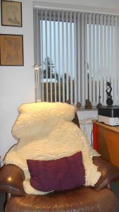 a couch with a blanket on it with a window at Enkeltværelse in Vestervig