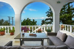 an outdoor patio with a couch and a table at PaxosBlue Suites & Villas in Gaios