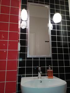 een badkamer met een wastafel en een spiegel bij Cozy studio for couple near Polytechnic University in Lviv