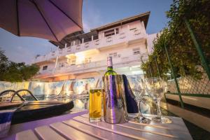 un tavolo con una bottiglia di vino e bicchieri di Blue Elephant Boutique Hotel a Negombo