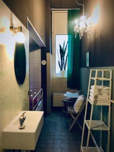 ein Badezimmer mit einer Badewanne, einem Waschbecken und einem Tisch in der Unterkunft Lekkerurlaub in Berlin