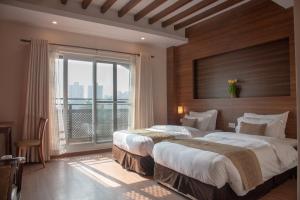 two beds in a hotel room with a large window at Sunshine Boutique Hotel in Kathmandu