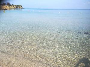 a body of water with a beach and rocks at Il Galeone B&B in Pulsano