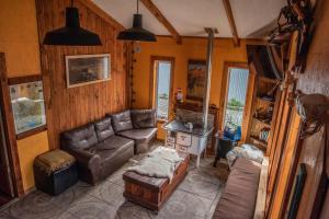 uma sala de estar com um sofá de couro e uma mesa em Puma House em Puerto Natales