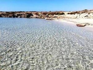 a beach with crystal clear water and some rocks at Il Galeone B&B in Pulsano