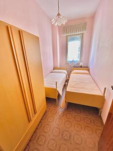 ein kleines Zimmer mit 2 Betten und einem Fenster in der Unterkunft VacanzeMareCervia Appartamenti Terzo Piano in Cervia