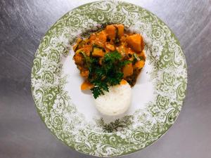 un plato de comida con arroz y verduras. en African Relish - Akkedis Cottage, en Prince Albert