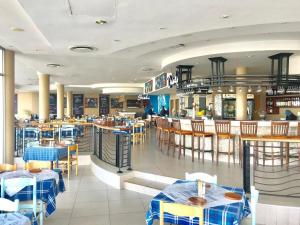 a restaurant with tables and chairs and a bar at OCEANPEARL 209 in Strand