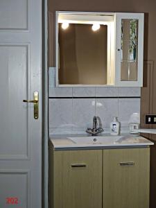 uma casa de banho com um lavatório e um espelho em Affittacamere Arancio em Lucca
