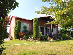 a house with green trees in front of it at Lagoon Beach House in Nea Potidaea