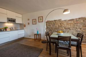 cocina y comedor con mesa y pared de ladrillo en Proconsolo Bargello Apartment by Mamo Florence, en Florencia