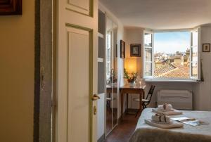 una camera con due letti e un tavolo e una finestra di Mamo Florence - Proconsolo Bargello Apartment a Firenze